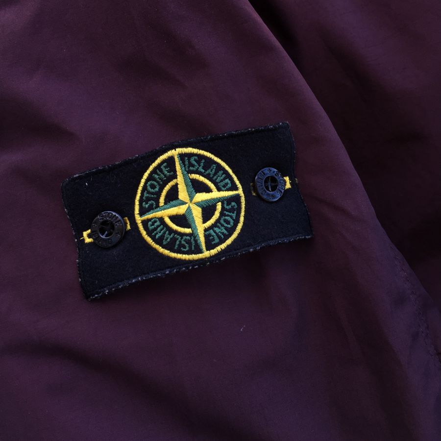 stone island badge on purple jacket